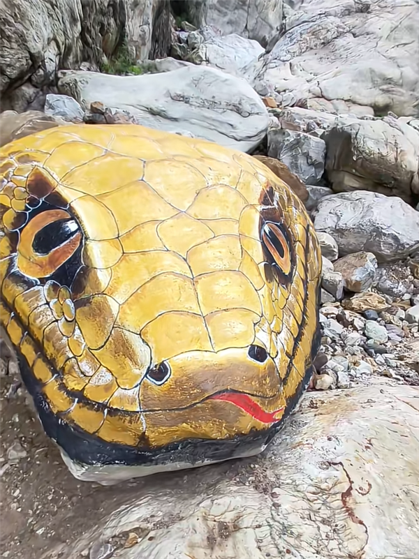 河南一景点石头被彩绘成巨型蛇头 栩栩如生 让人心惊